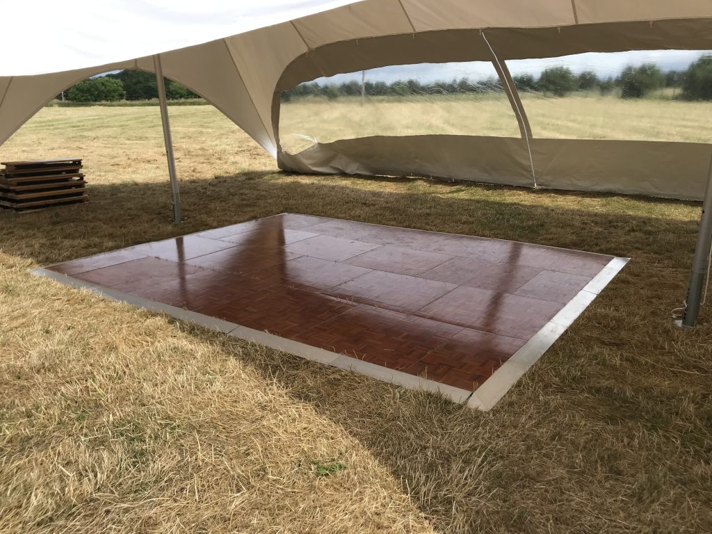 A parquet dance floor hire to go outside on grass under a stretch tent. 