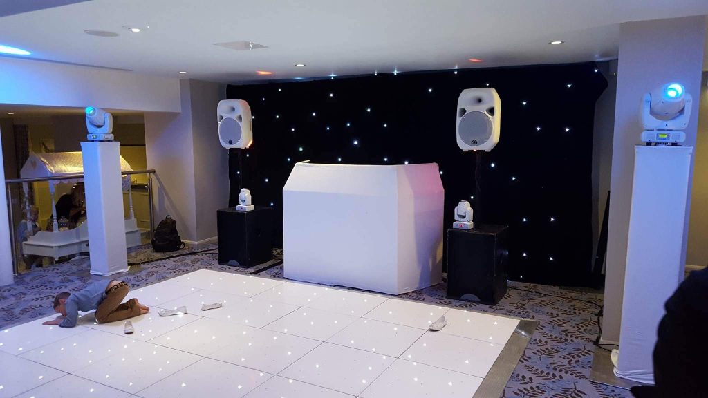 Small white starlit dance floor with DJ and disco in the background