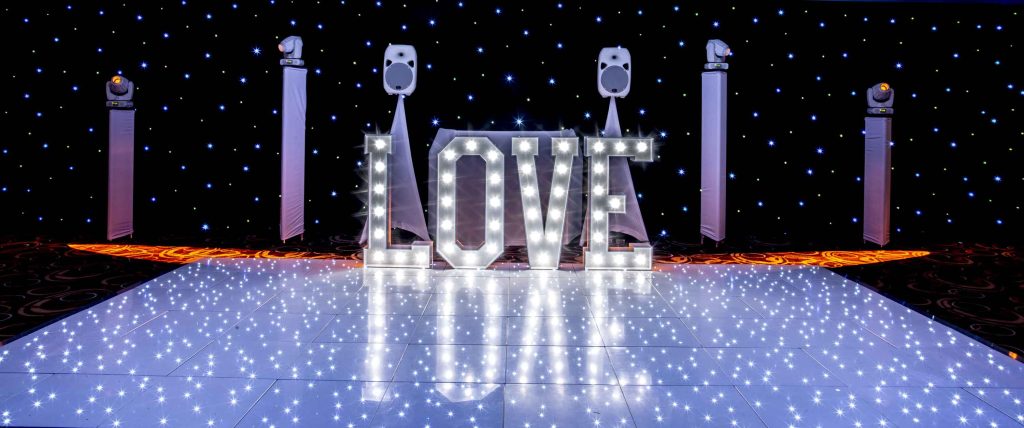 Very shiny white dance floor with light up LOVE and white disco setup