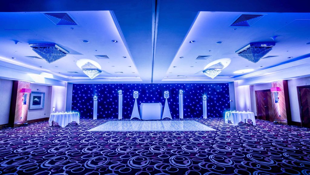 Disco setup with a white led dance floor and black backdrop.