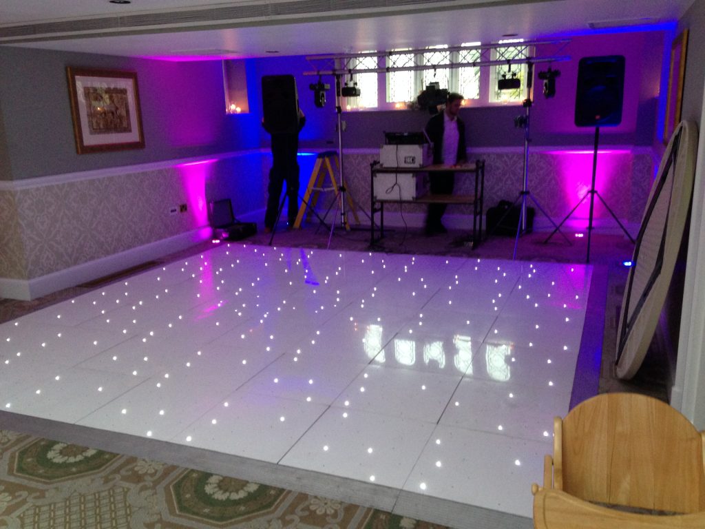 Shiny white led dance floor with DJ setting up behind