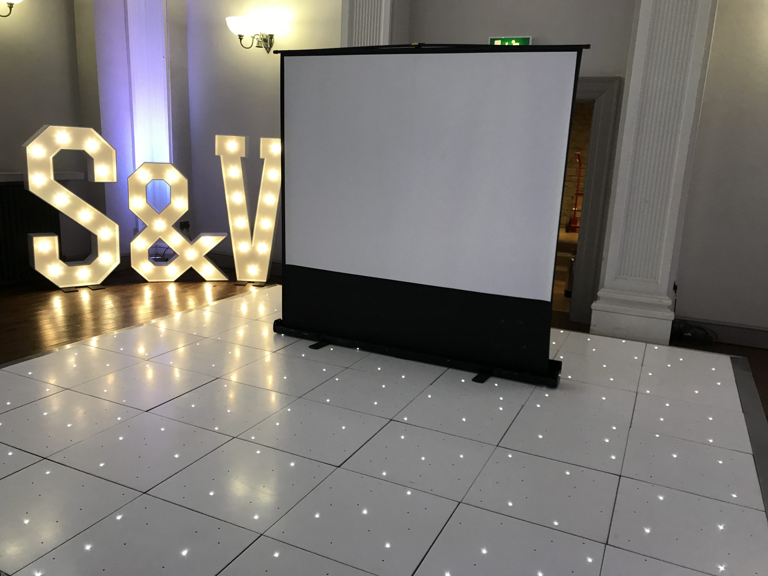 White starlit dance floor with light up S & V letters and a projection screen
