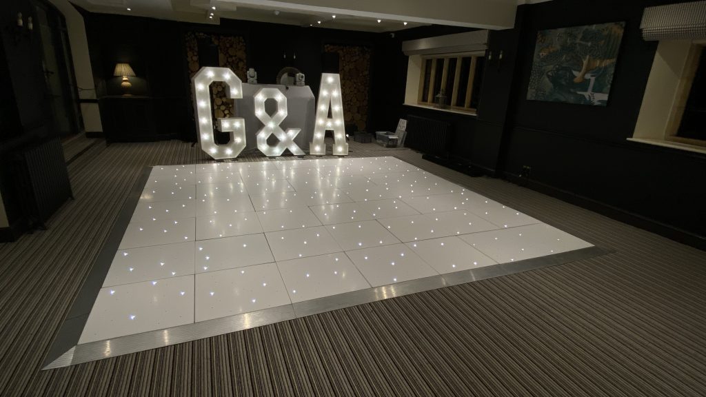 Giant light up letters behind a white twinkle dance floor