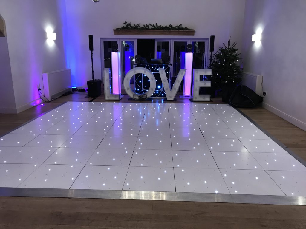 LED starlit dance floor in white with giant LOVE behind and DJ behind too