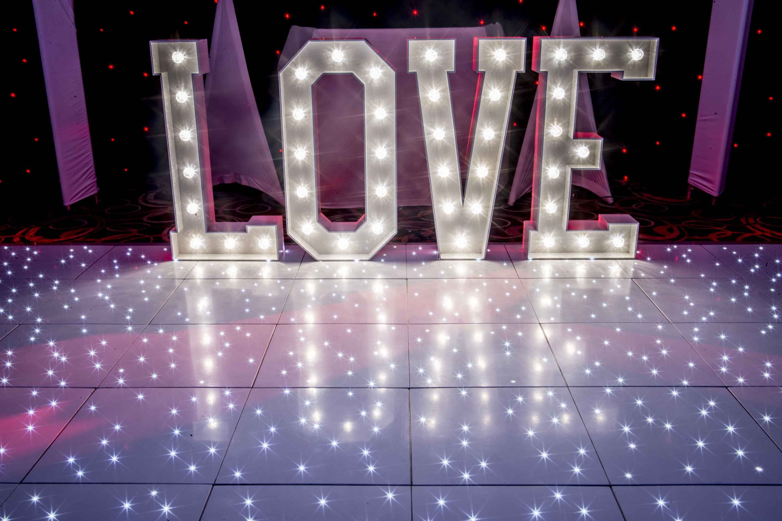 Bright twinkle white dance floor with giant light up LOVE behind