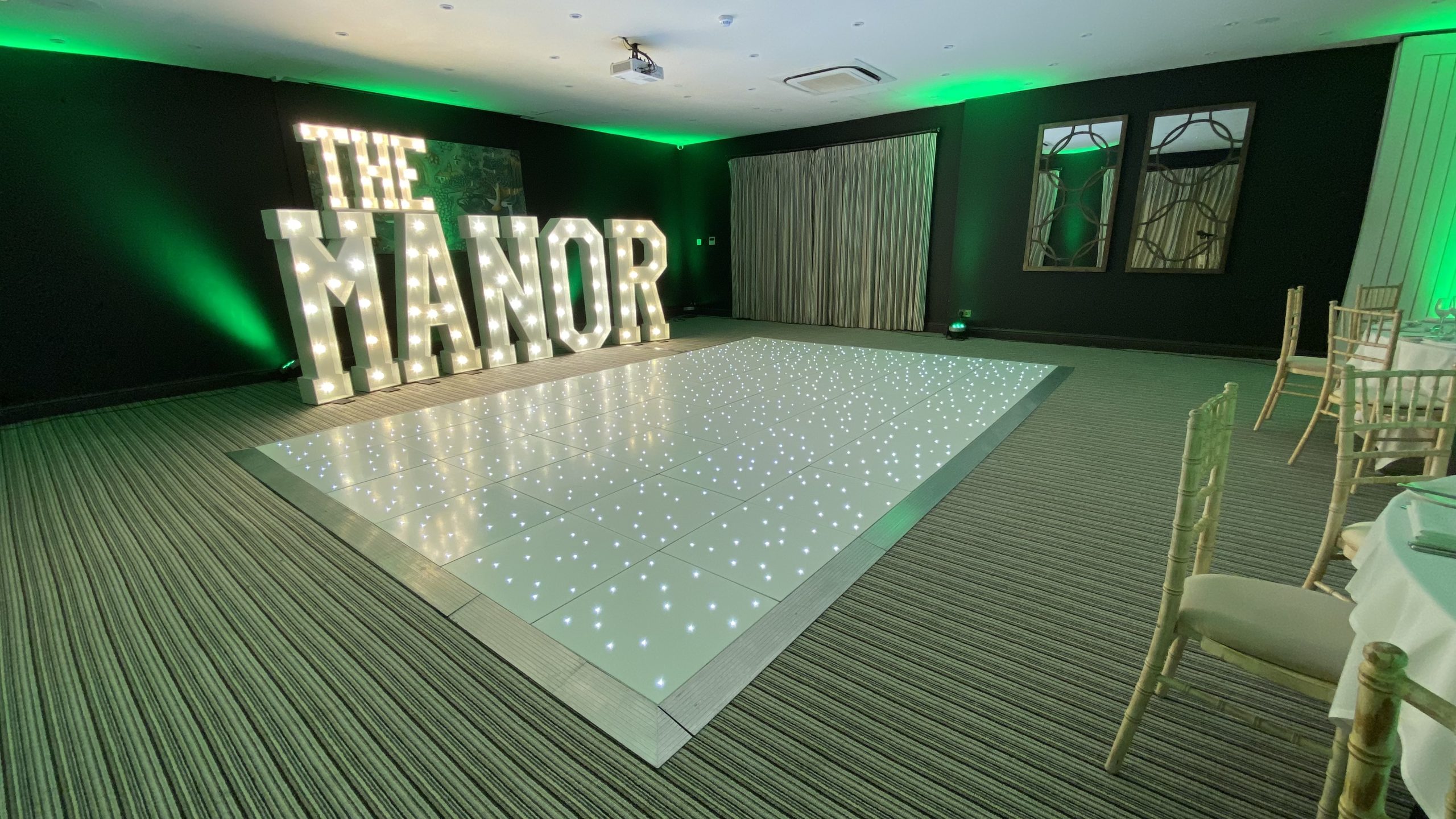 Starlit dance floor in white with green room lighting and giant light up letters