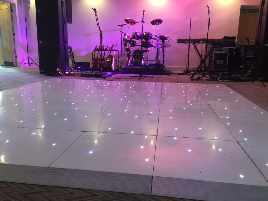 white dance floor twinkling with band setup behind