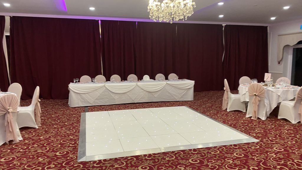 White starlit dance floor in front of top table for a wedding. 