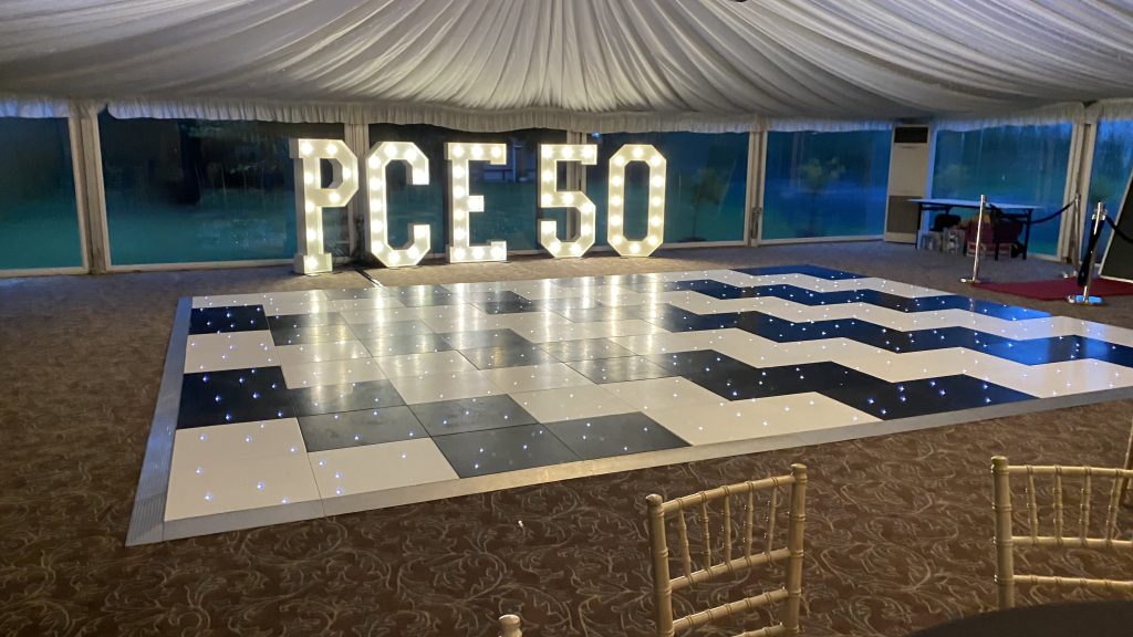 Black and white offset Starlit dance floor with light up letters PCE 50 behind