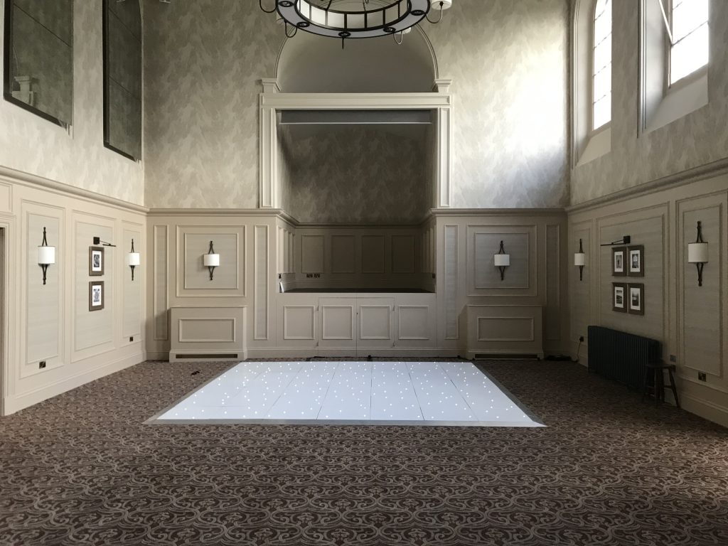 Simple white led dance floor in front of a stage at Stanbrook abbey