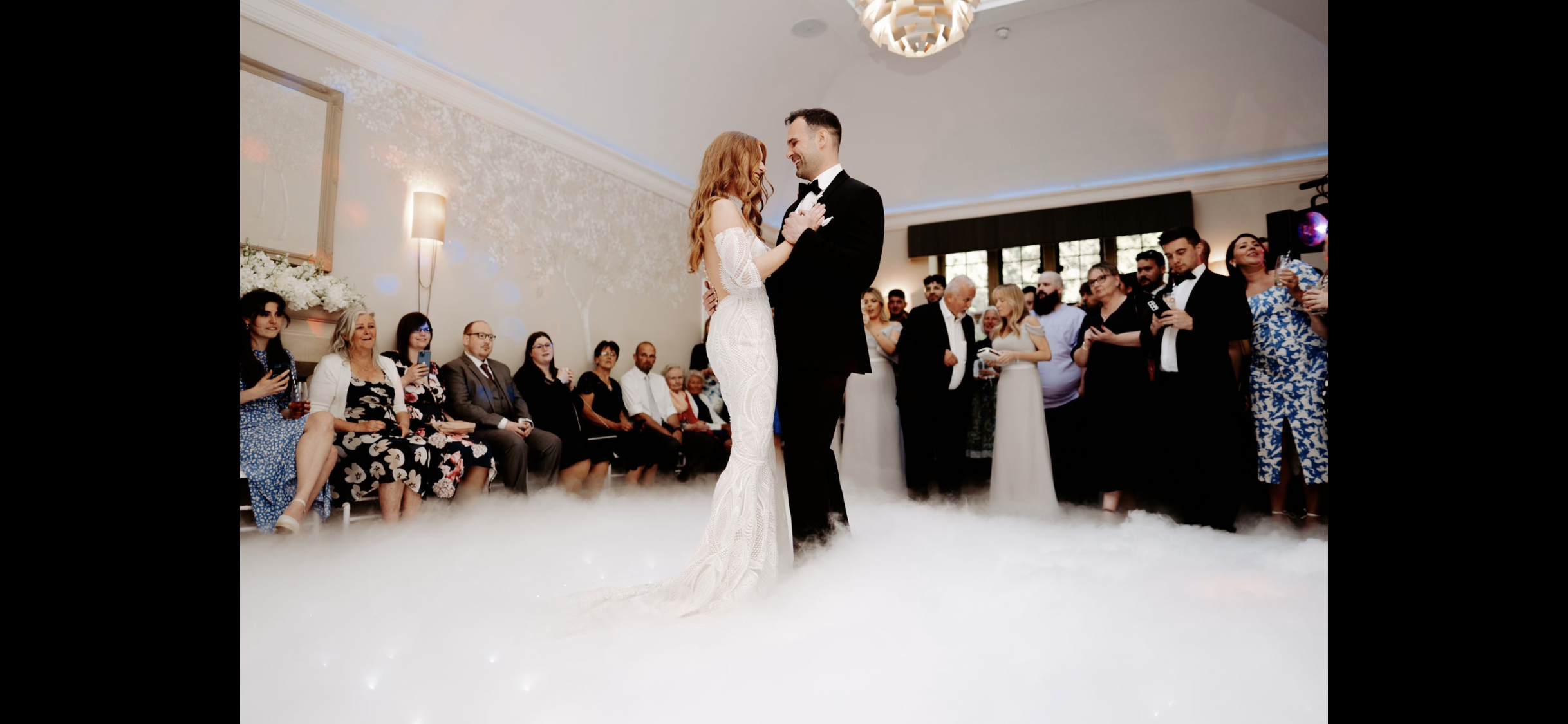 Couple performing a first dance on a starlit white dance floor