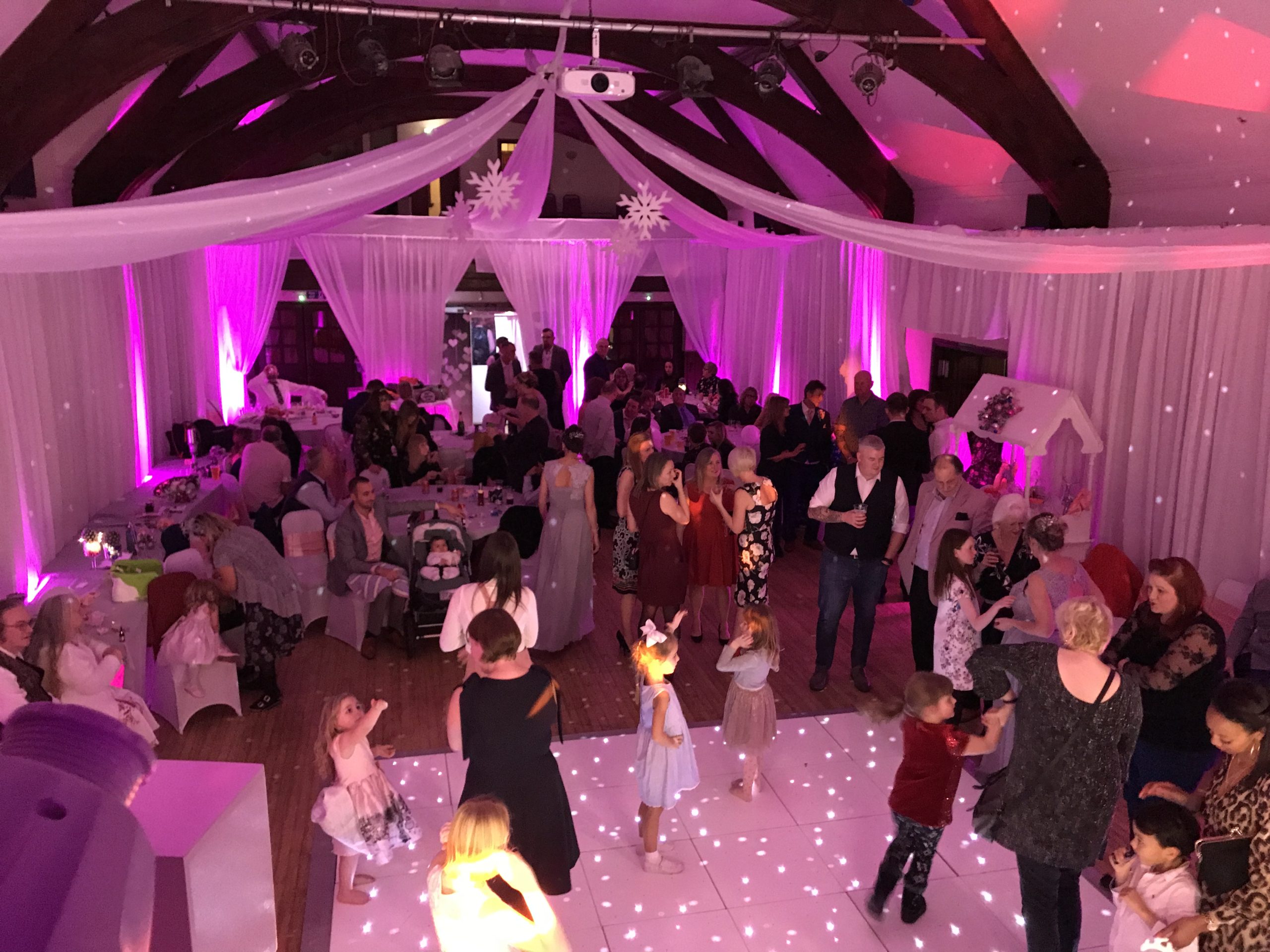 White starlit dance floor surrounded by tables with people dancing