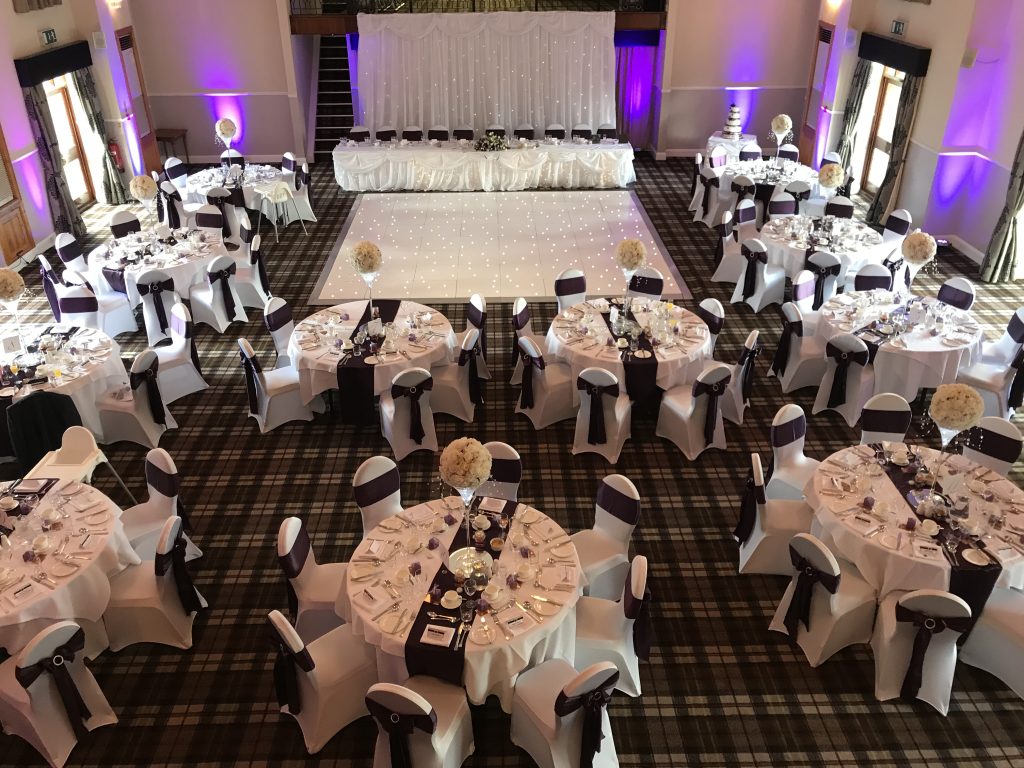 A white starlit dance floor setup with tables around for a wedding