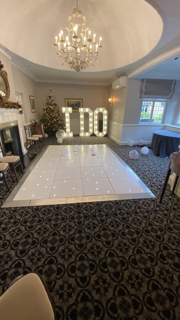 Small white starlit dance floor with I DO in light up letters behind