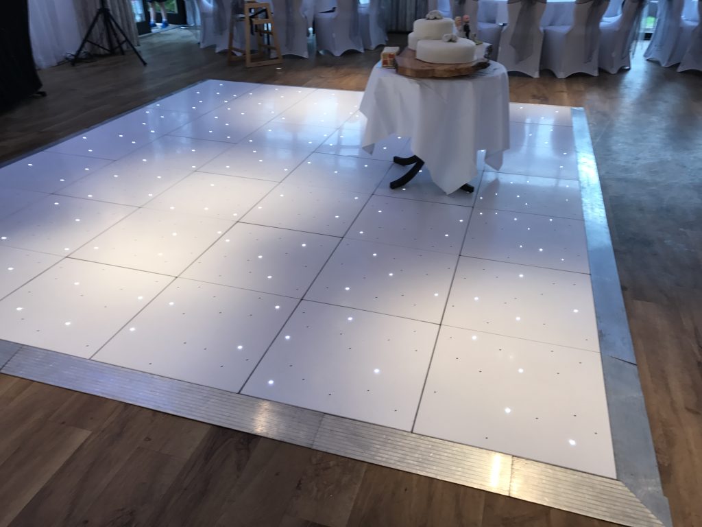 White starlit dance floor with a wedding cake table on top