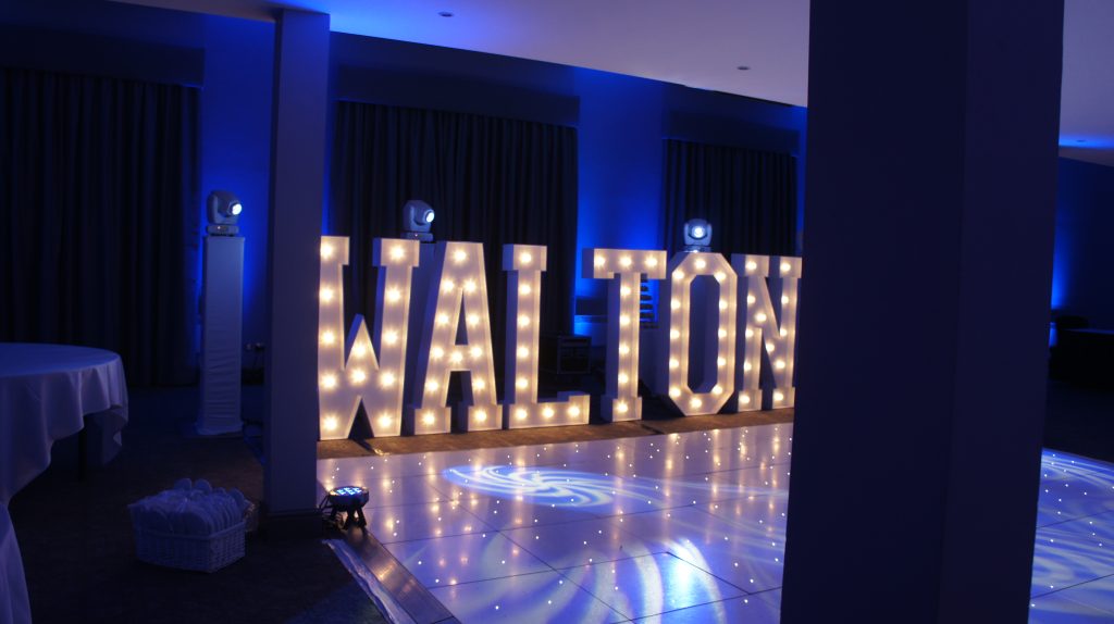 White starlit dance floor with the word WALTON in light up letters