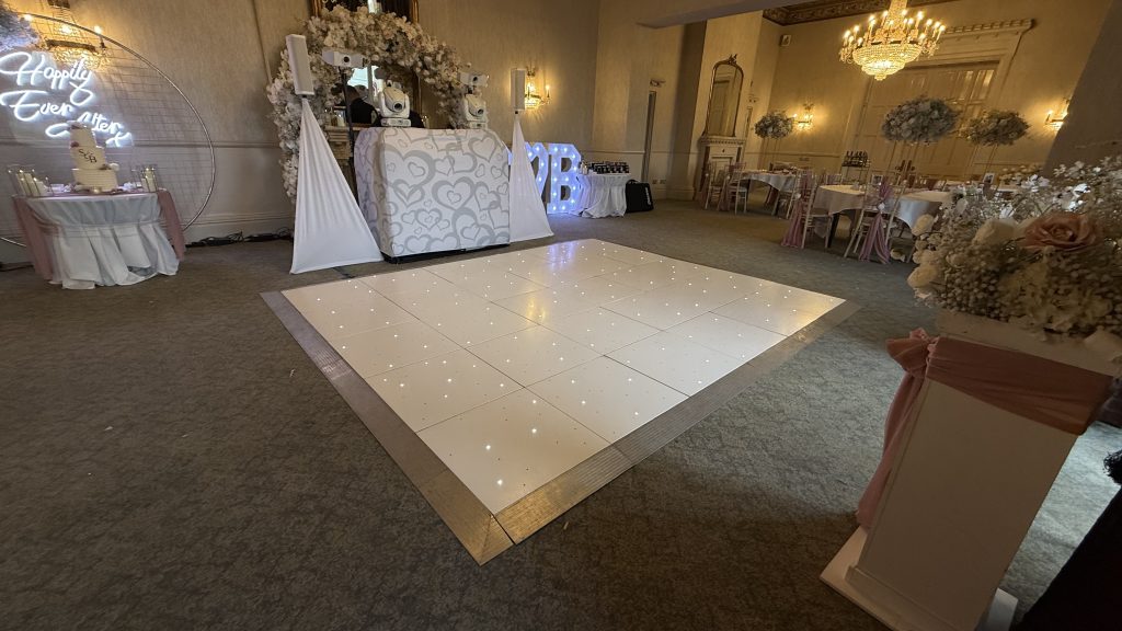 White starlit dance floor with DJ booth behind