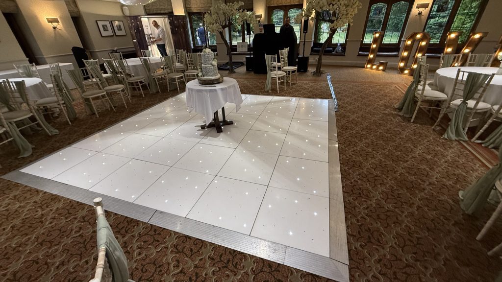 A starlit dance floor with a wedding cake positioned in the middle