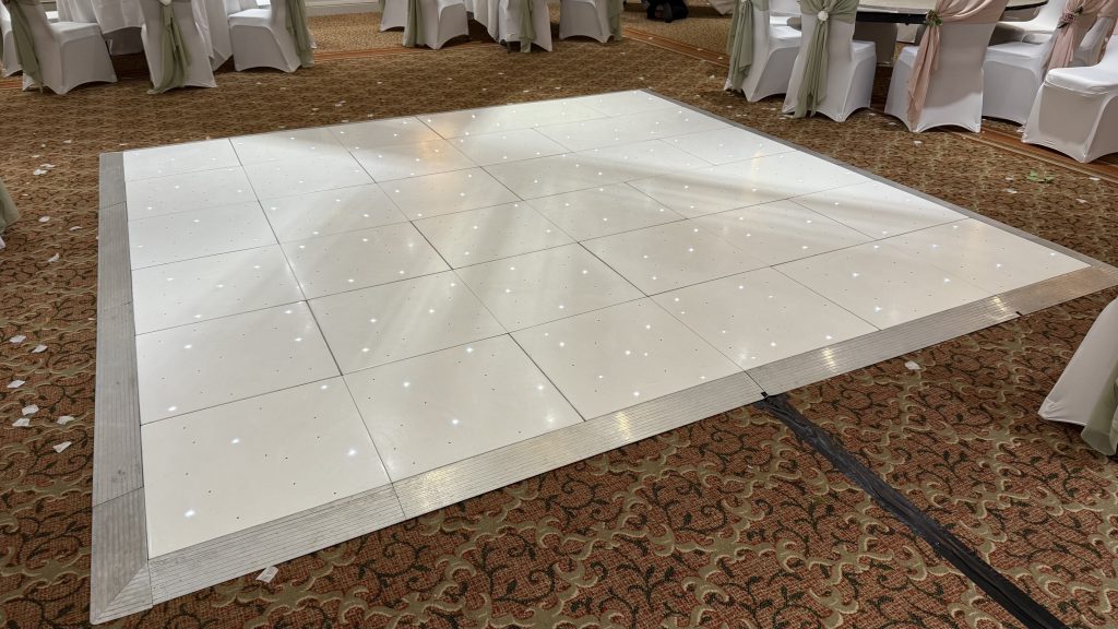 White starlit led twinkle dance floor in the middle of a wedding function room