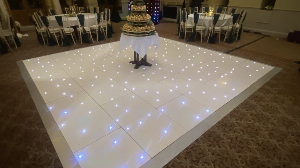 A white LED twinkle dance floor with a wedding cake in the centre