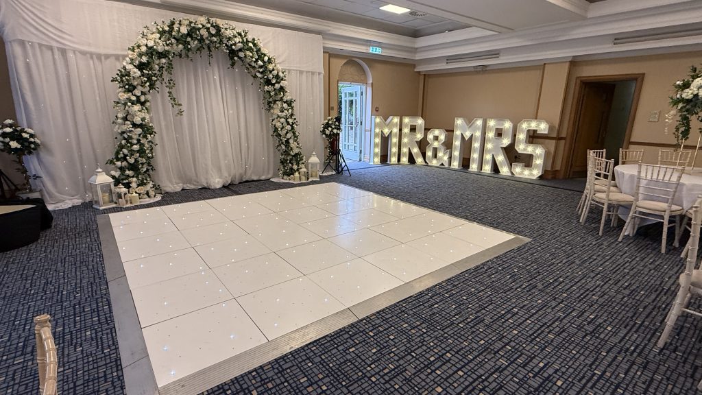 light up starlit dance floor with floral arch and light up MR & MRS
