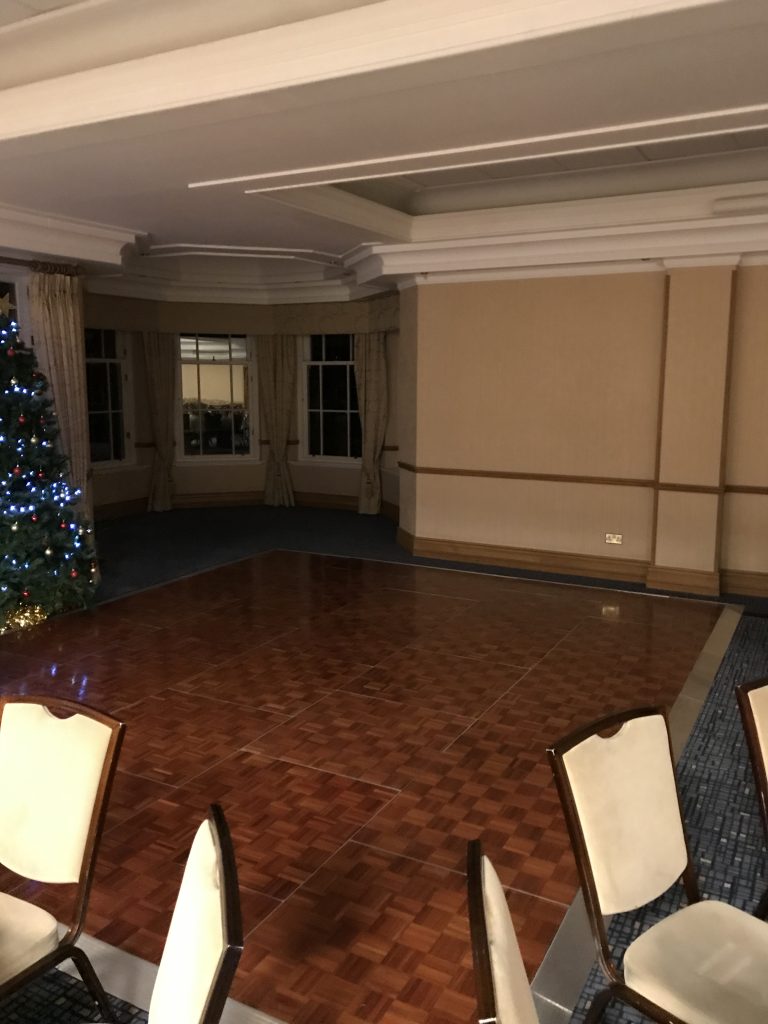 Wooden parquet dance floor in the corner of a room