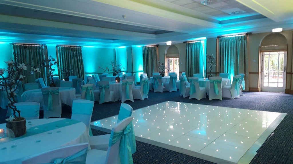 white dance floor starlit with blue lighting around the room