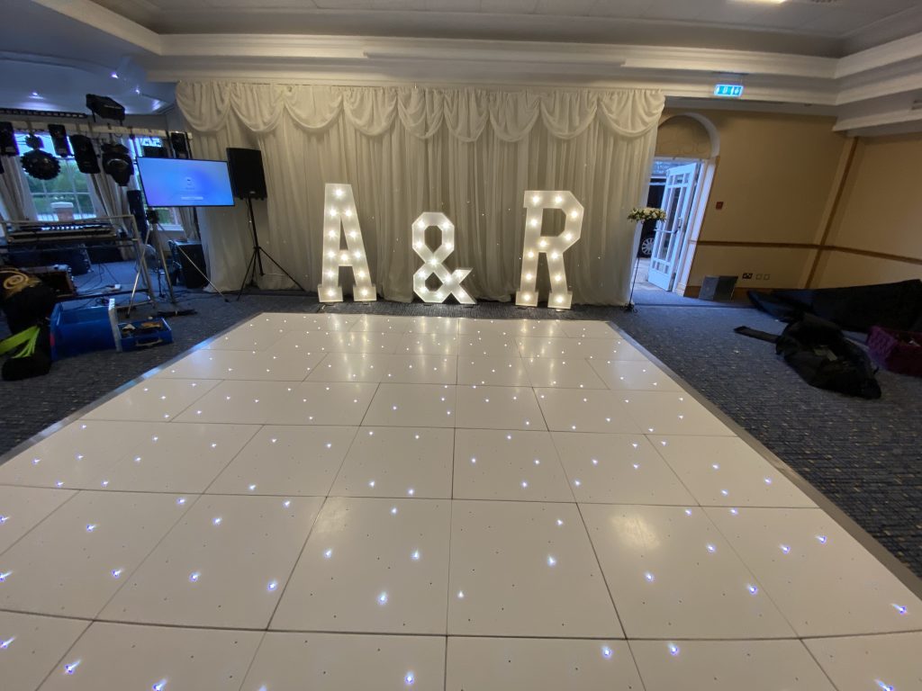 White led dance floor with light up A & R letters and white backdrop
