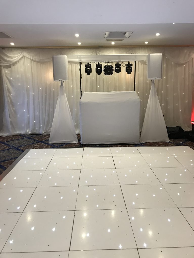 White disco setup with a white backdrop and a white led starlit dance floor