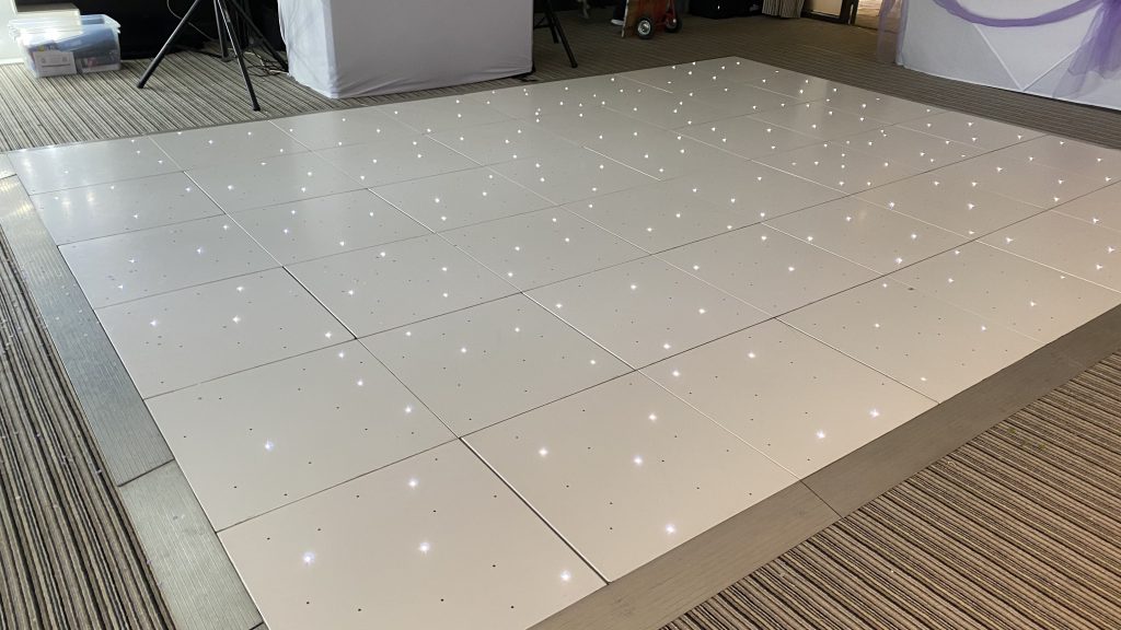 white starlit dance floor in front of a DJ setup