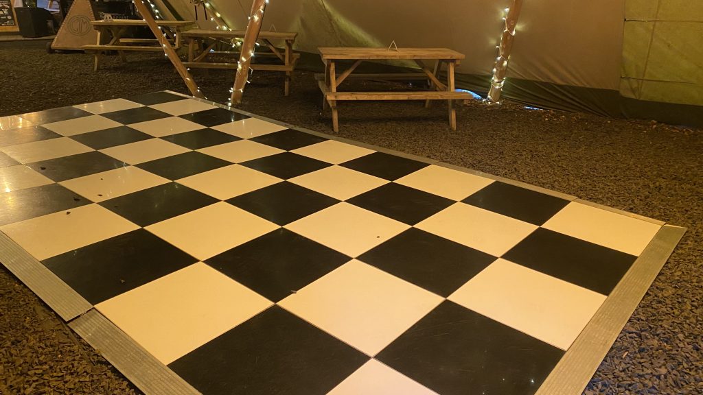 black and white chequered dance floor surrounded by picnic tables