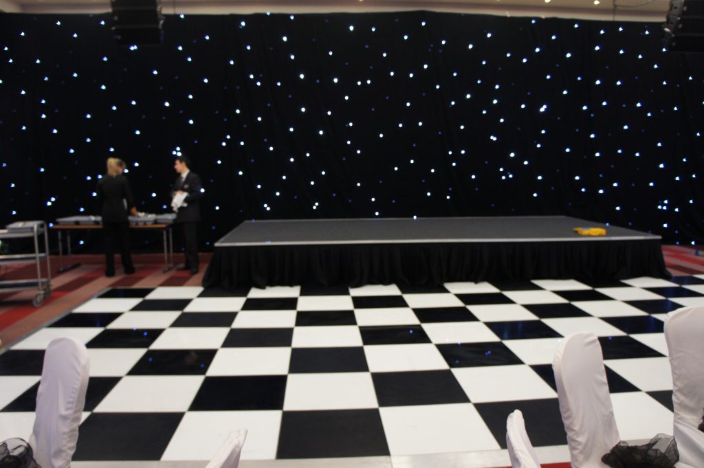 Black and white dance floor in front of a stage for a corporate event