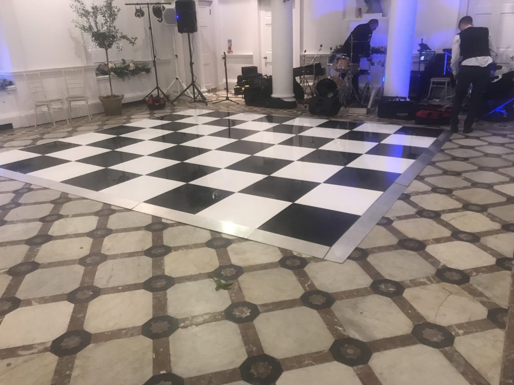 Black and white chequered dance floor in front of a band setting up