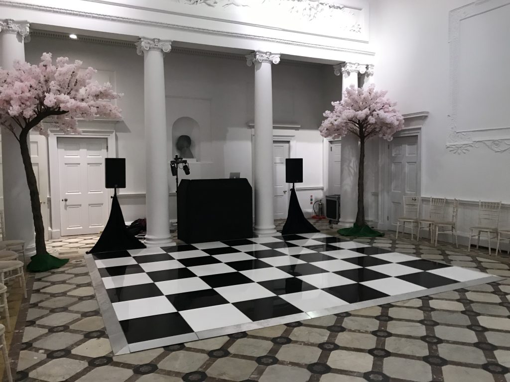 black and white dance floor with DJ setup and blossom trees