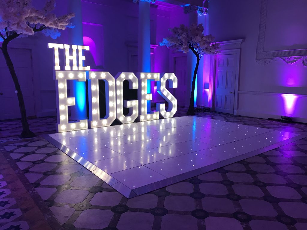 white starlit led dance floor with light up letters spelling THE EDGES
