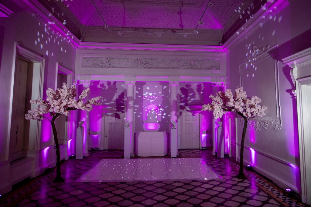 white starlit dance floor withpink lighitng and blossom trees