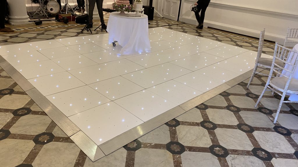 White starlit dance floor with cake table in the middle