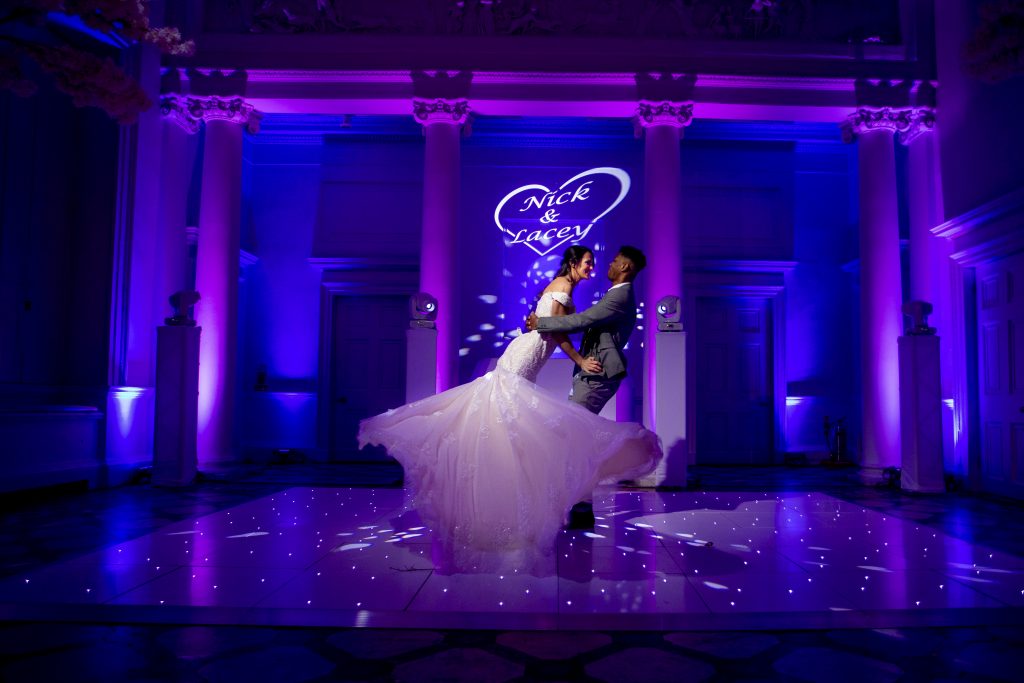 Wedding couple on a white starlit dance floor with purple and blue lighting