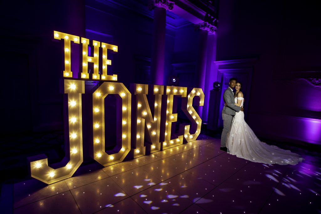 White starlit dance floor with couple and light up letters THE JONES