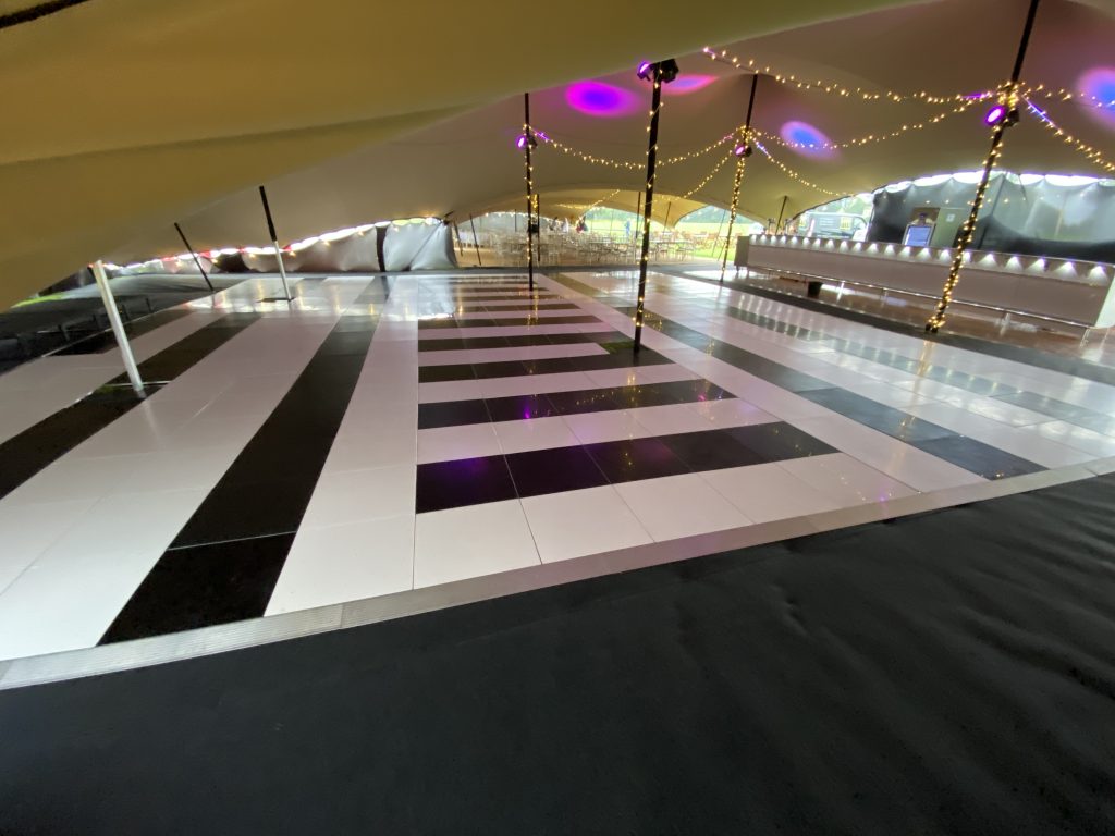 48ft × 38ft black and white dance floor installed inside a large marquee at Cirencester Park Polo Club