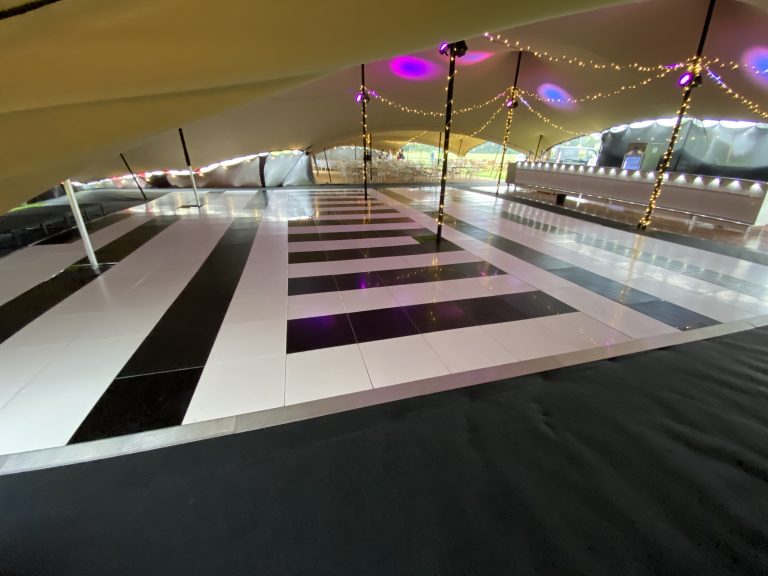48ft × 38ft black and white dance floor installed inside a large marquee at Cirencester Park Polo Club
